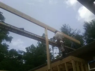 Carpenter setting a ridge beam over a new addition frame — Ice Dam Removal by Roofing Brothers in Holdingford